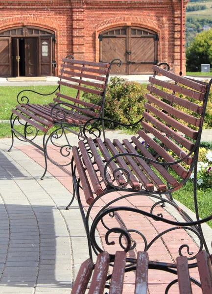 Oyun parkında işlenmiş demir parmaklıklı ahşap banklar.