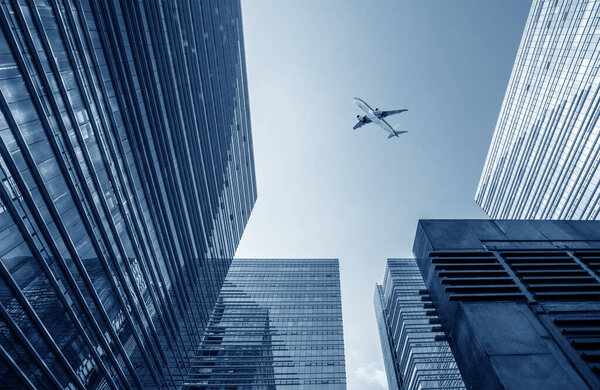 Modern urban picture, airplane on the sky.