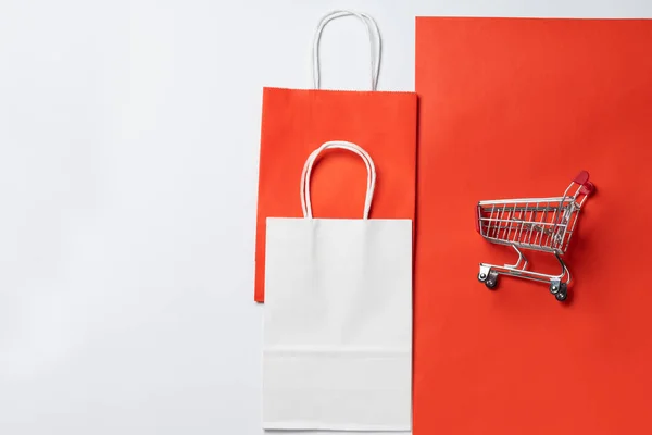 Icono de ventas. Carro de carro para supermercado y paquete sobre fondo rojo —  Fotos de Stock