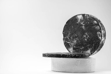 Beyaz yuvarlak kaide podyumu. Beyaz arkaplandaki spot ışıklarıyla soyut çimento kaidesi.