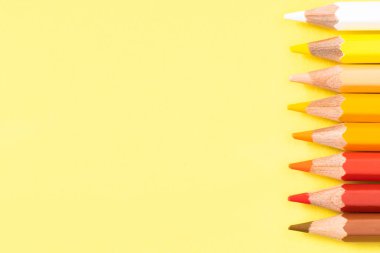 Sarı arkaplanda renkli kalem. Mesaj için yer. Üst görünüm