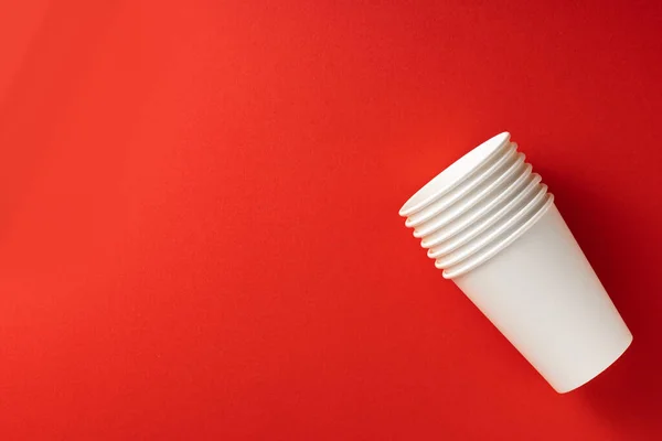 Tazas de papel blanco sobre fondo rojo. Vista superior.Lugar para texto.Concepto de ecología — Foto de Stock