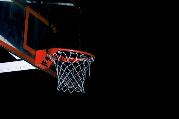 在黑暗的树后的篮筐上打篮球 — 图库照片