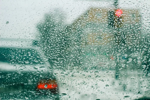 氷と雪と水で覆われた汚れたフロントガラスを通って道路の非常に悪い景色は ぼんやりとした前景とボケの効果を背景にしています — ストック写真