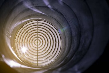 Havalandırma ızgarası dağıtıcı gece kanalına monte edilmiş, ön ve arka plan bulanık.