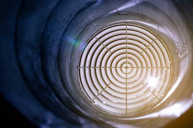 Havalandırma ızgarası dağıtıcı gece kanalına monte edilmiş, ön ve arka plan bulanık.
