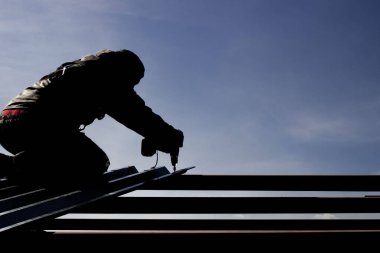 Güvenlik halatına sigortalı bir endüstriyel dağcı yüksek irtifada metal yapılar kurma görevini yerine getiriyor.