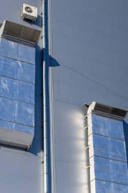 Endüstriyel bilgi dışında büyük havalandırma kanalları ve mavi gökyüzüne karşı termal yalıtım.