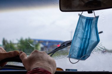 İnsanlar Covid-19 maskelerini arabanın ön camına, ön planına ve arka planına Bokeh efektiyle bulanık asmayı alışkanlık haline getirmişler.