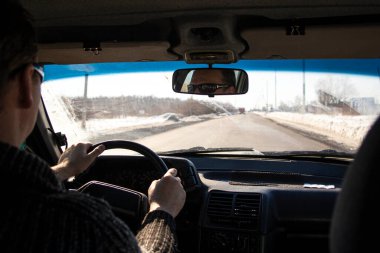 Yağmur sırasında arabanın iç kısmının kirli ön camdan görünüşü, zor meteorolojik koşullarda yolda, ön ve arka planlar bokeh etkisi ile bulanıklaşır.