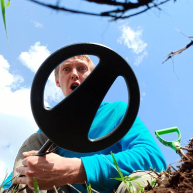 Metal araması. Adamın biri elinde metal dedektör tutuyor. Hazineleri arayın. Antika sikkeleri ara.