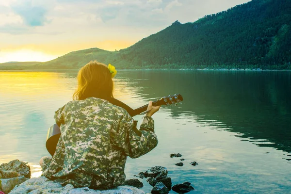 Dziewczyna Krzyczy Gitarze Zajęciach Jogi Brzegu Czystego Jeziora Siedzi Kamieniach — Zdjęcie stockowe