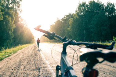 Bisiklet, ön ve arka plandan kaçan bir adamın silueti bokeh etkisi ile bulanıklaştı