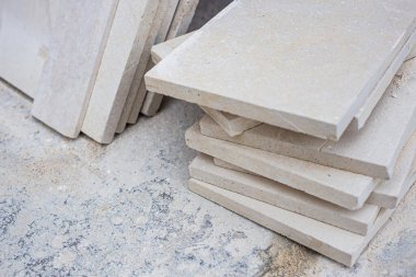 İnşaat halindeki bir verandanın arka planına karşı yenilenmiş büyük doğal mermer levhalar, yakın plan, bokeh etkisi ile bulanıklaşmış.