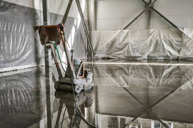 Bir polimer zemin inşa ve montajı sırasında bir inşaat alanında sıvı öz seviyelendirme için bir aracın yakın çekimi.