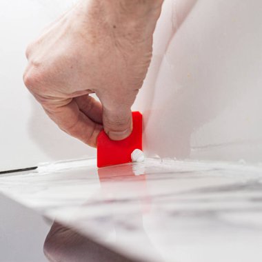 Porselen fayansların üzerinde plastik spatula ve silikon harç ile birleştirme, rahat bir yaşam için odaları tamamlama