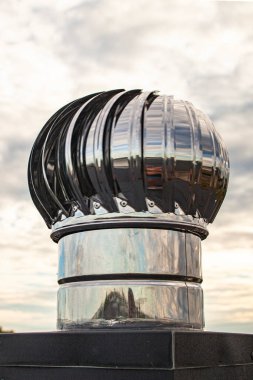 Endüstriyel bir binada havalandırma sorunlarını çözen çatıya monte edilmiş bir turbo saptırıcının yakından görüntüsü havalandırma borularından hava akışı ve egzoz akışı sağlıyor..