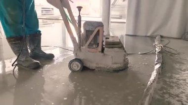 Betonun aşırı ısınmasını önlemek için zemini kalın bir su tabakasıyla dümdüz eden beton öğütücüye yakın plan..