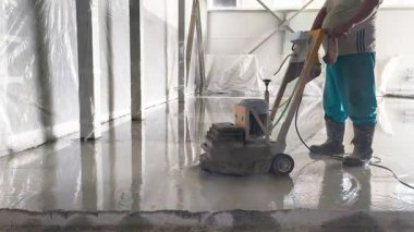 Betonun aşırı ısınmasını önlemek için zemini kalın bir su tabakasıyla dümdüz eden beton öğütücüye yakın plan..