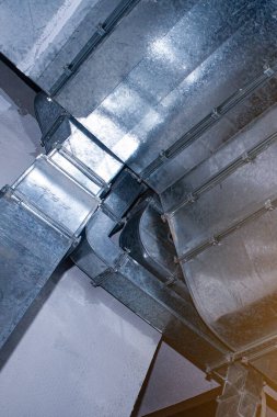 Havalandırma sisteminin tavanına hava akımı dağılımı ve iklim kontrolünü gösteren endüstriyel havalandırma kanalları yerleştirildi. Havalandırma. İnşaat. Altyapı inşaatı.