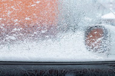 Kış donmuş araba penceresi, dondurucu buzlu cam arka plan. Ön manzara. Donmuş araba kış günü karla kaplanmış, ön cam ön cam manzarası ve karlı arka planda kaput. Mutlu yıllar..