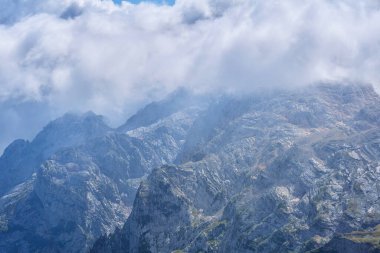 Görkemli kayalık dağ mahmuzları ve bulutların arasındaki boğazlar