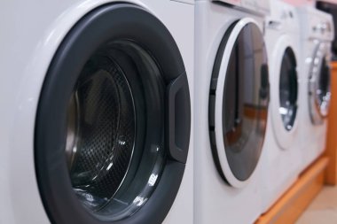 Bir ev gereçleri mağazasında satılık çamaşır makineleri satılıyor. Arka planda bulanıklık var.