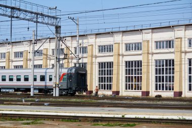 Perm, Rusya - 07 Ağustos 2020: Depo binasının arka planına karşı yolcu vagonlarıyla çalışma