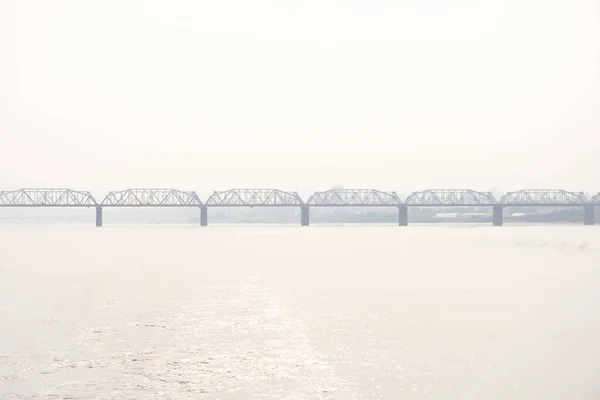 Σιδηροδρομική Γέφυρα Πάνω Από Ένα Ευρύ Ποτάμι Και Σιλουέτα Μιας — Φωτογραφία Αρχείου