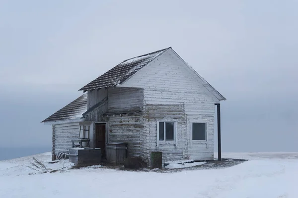 雪に覆われた冬の山の上にある古い木造の家は — ストック写真