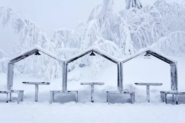 street furniture - gazebos with picnic tables - in a frosty winter park