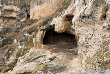 Kayalık bir yamaçtaki ortaçağ mağarasının şehir kalesinin kalıntıları.