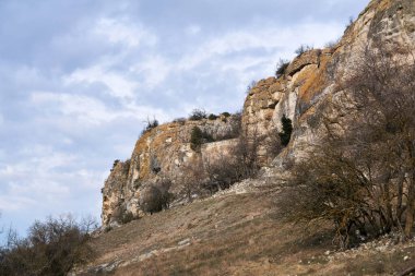 Orta Kırım 'ın kış arazisi Cuesta' nın kenarında kayalık uçurumlar ve kayalar arasındaki antik kale duvarı.