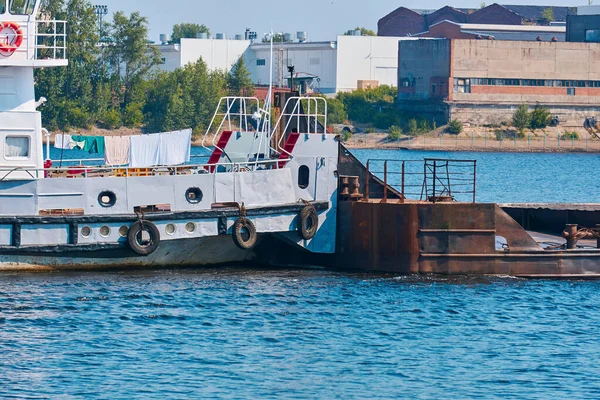 towboat pushes dry bulk cargo barge on the river close-up