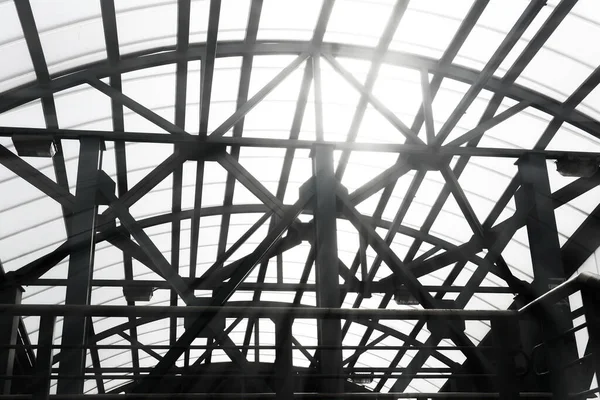 sun shines through the lattice structures of the covered pedestrian overpass