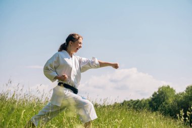 Genç kız dışarıda karate yapıyor, Kiki 'yi kullanarak Oi Zuki yapıyor.