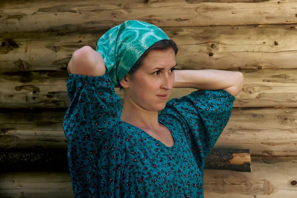 一位身着传统农民服装的妇女的肖像在木墙的后面系了一条头巾 — 图库照片