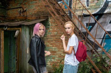 İki genç kız eski bir binanın avlusunda emekli oldu.