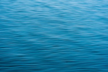 Dalgalarla soyut mavi su arkaplanı bulanıklaştı