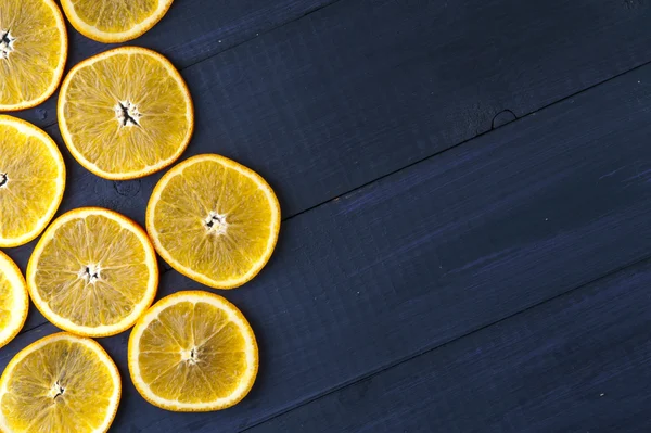 Fatias de laranja no fundo de madeira azul escuro — Fotografia de Stock