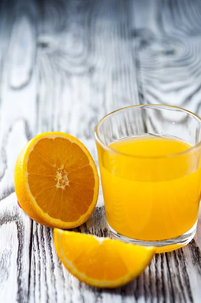 Jugo de naranja con rodajas en mesa de madera —  Fotos de Stock