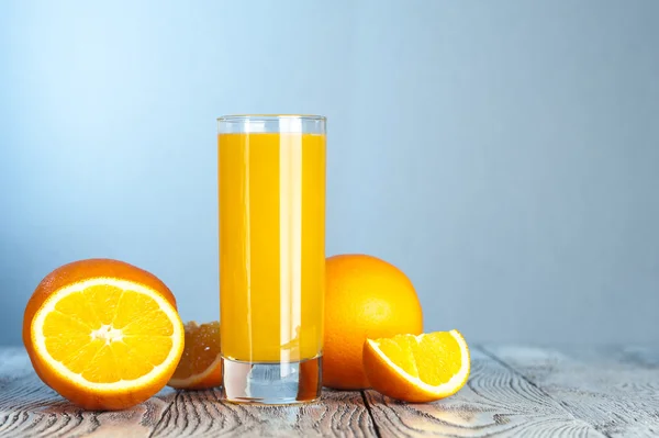 Jugo de naranja recién exprimido en mesa de madera —  Fotos de Stock