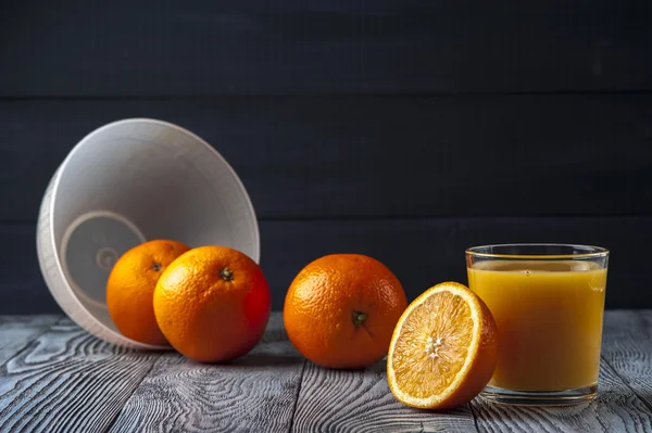 Sumo de laranja espremido na hora, metade de laranja na mesa de madeira — Fotografia de Stock
