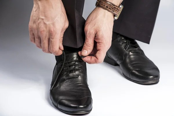 Zamknij się człowiek nogi i ręce wiązanie sznurówki do butów — Zdjęcie stockowe