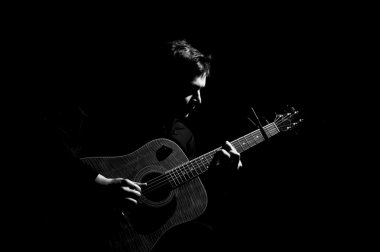 Akustik gitarla çalan adam