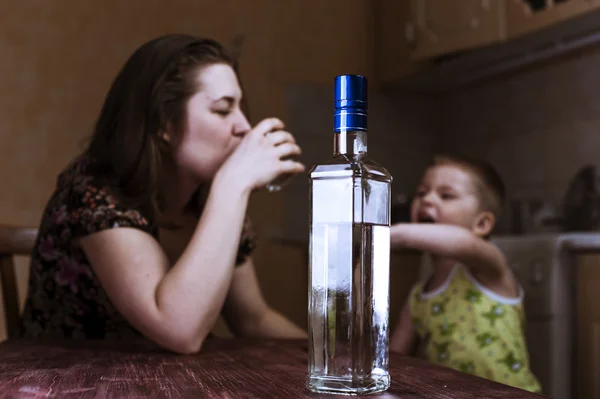 Mulher com bebida alcoólica e seu filho — Fotografia de Stock