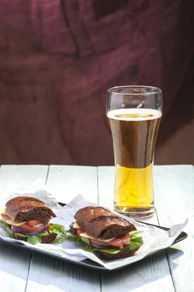 Zöldséges lazac, rozs kenyér és üveg sör két szendvicsek — Stock Fotó