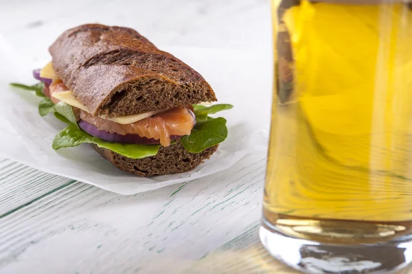 Leckeres Sandwich mit Fisch und Bierglas — Stockfoto