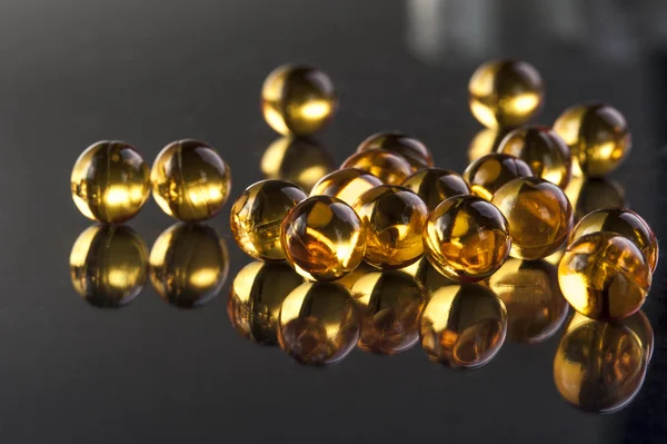 Omega capsules op zwarte achtergrond — Stockfoto