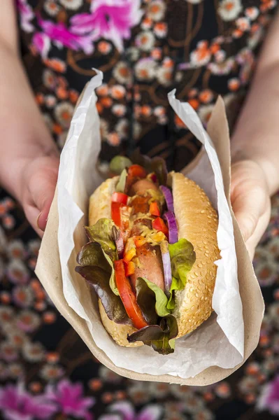 A női kéz finom hotdog — Stock Fotó